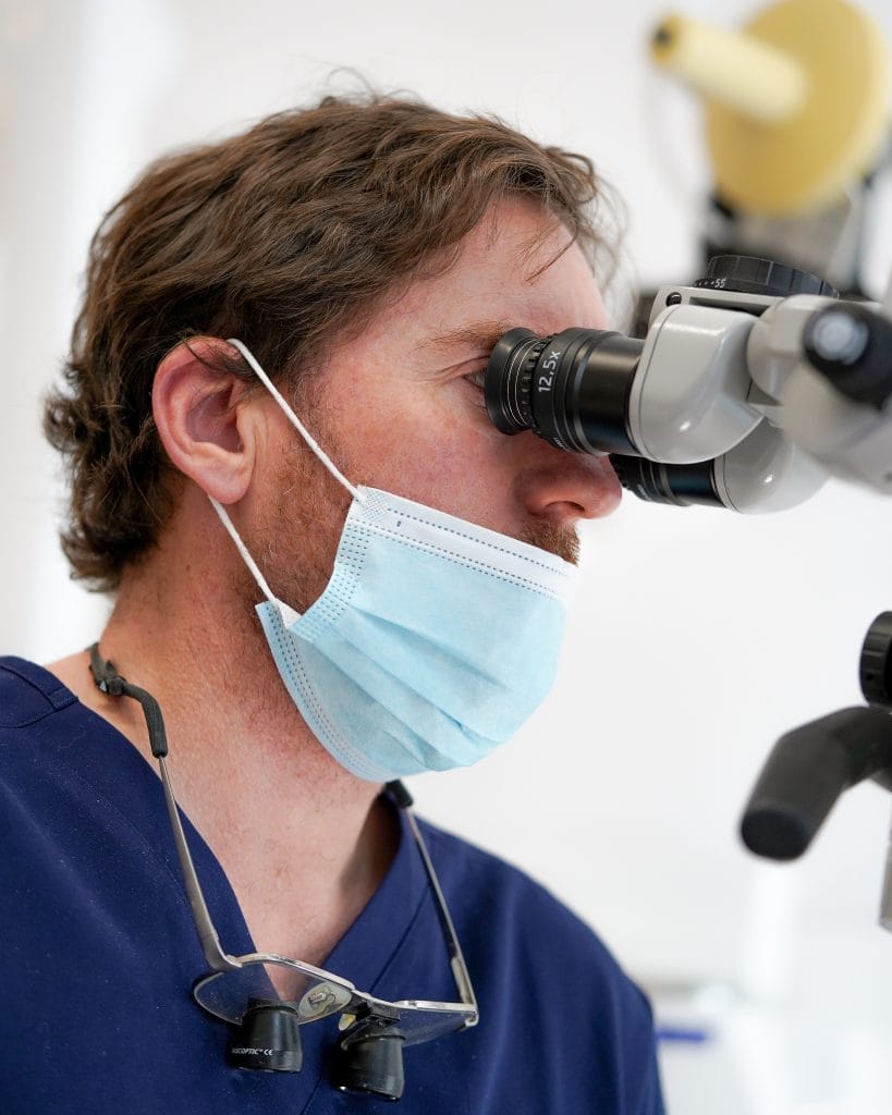 El Dr. David García Baeza trabajando con microscopio de alta magnificación en CIMA Dental