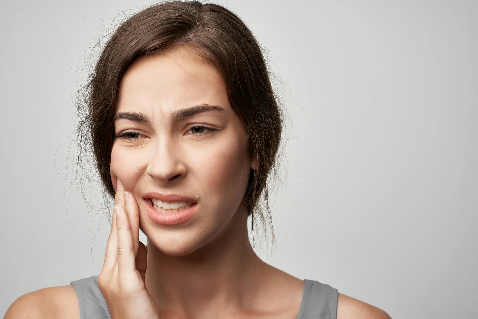 Mujer con dolor de dientes por apretar la mandíbula (bruxismo)
